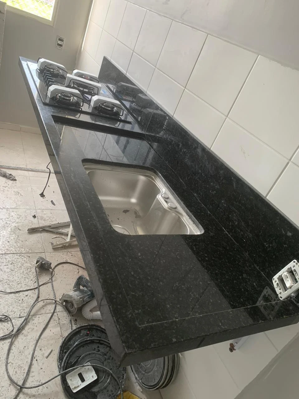 Detalhe de borda e recortes para cuba e cooktop em bancada de granito escuro